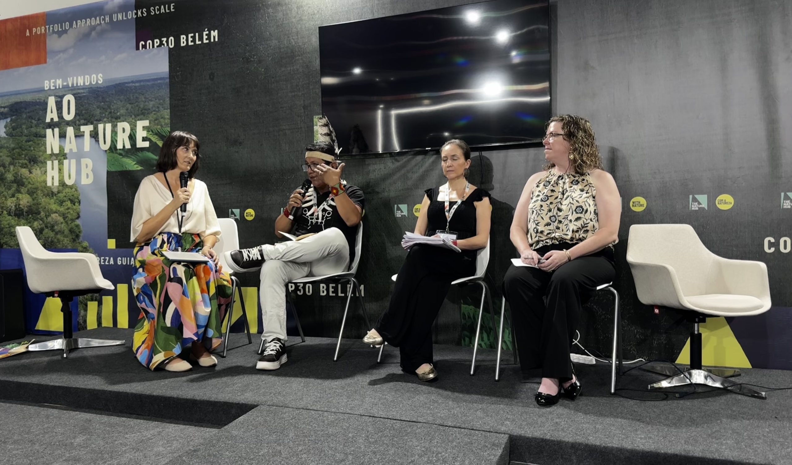 A four-person panel at the Nature Hub Pavilion, COP30 Belem, one speaker holding a microphone