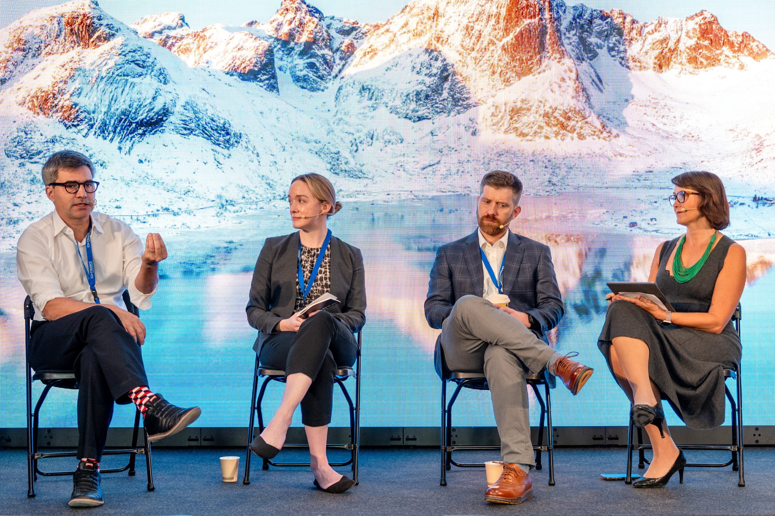 A four-person panel on stage at the Nordic Climate Finance Summit, Oslo, the moderator holding a tablet